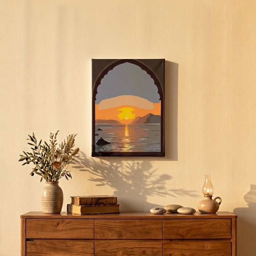 Une console en bois de noyer moderne dans un salon éclairé par le soleil couchant. Sur le meuble sont posés un vase en céramique avec de branches séchées, des livres vintage, des galets et une lampe à huile allumée. Au-dessus, un petit tableau (30x20 cm) accroché au mur représente un coucher de soleil sur la mer à travers une arche de style mauresque.